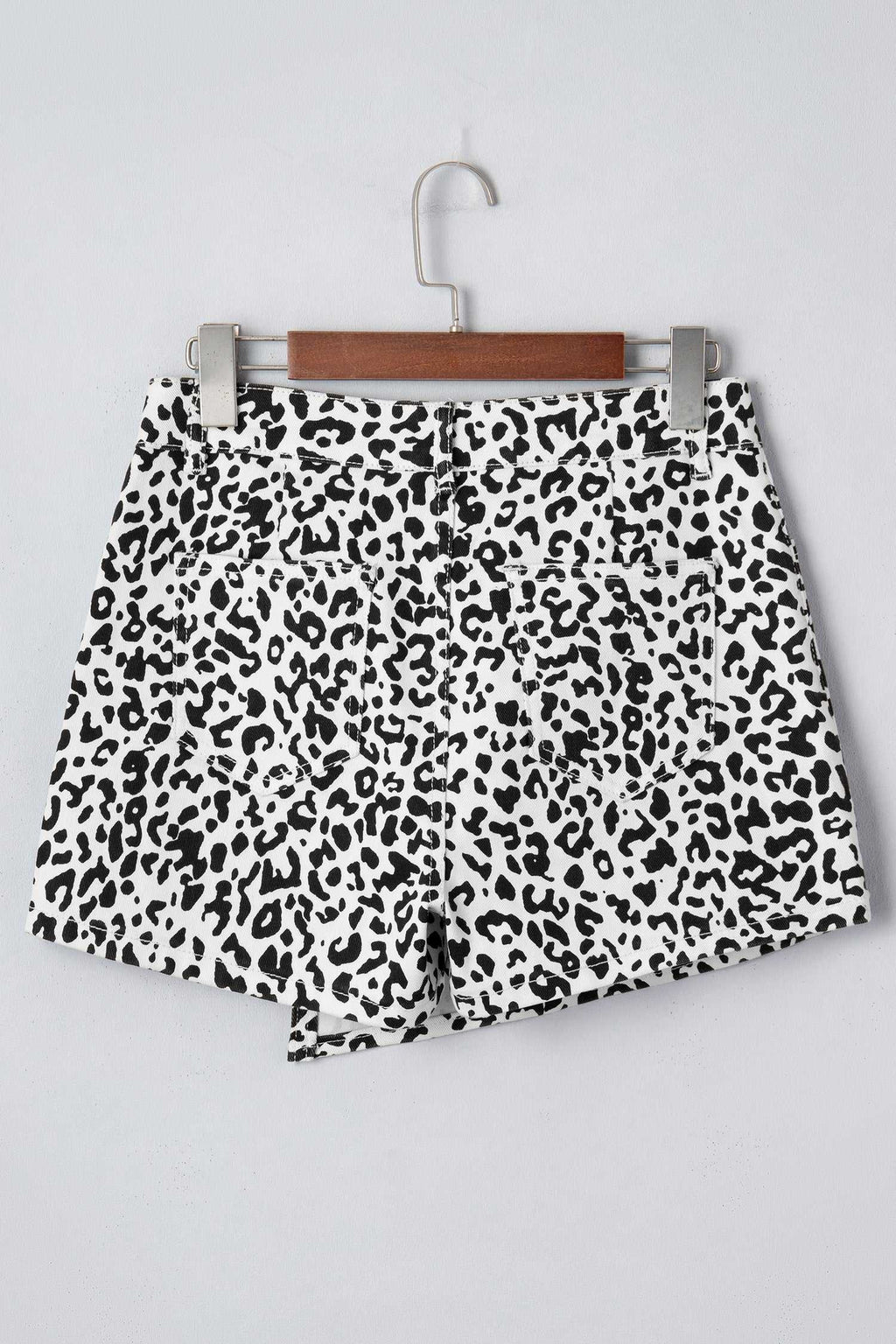 Black Leopard Button Overlap Denim Shorts in white with black leopard print and a button overlap front design.