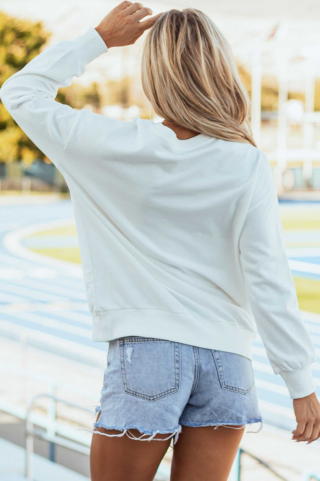 White Mallard relaxed pullover sweatshirt in white cotton-poly blend with long sleeves and ribbed cuffs visible from the back