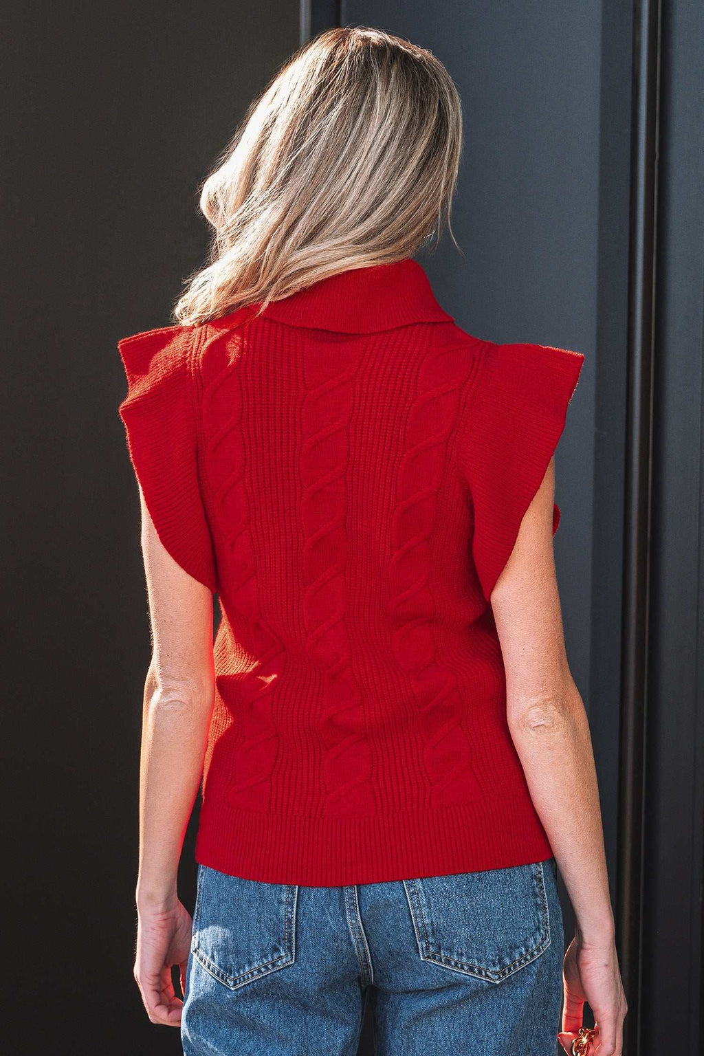 Jet Stream red cable knit sleeveless sweater with ruffle detailing and a high collar in soft stretchy fabric