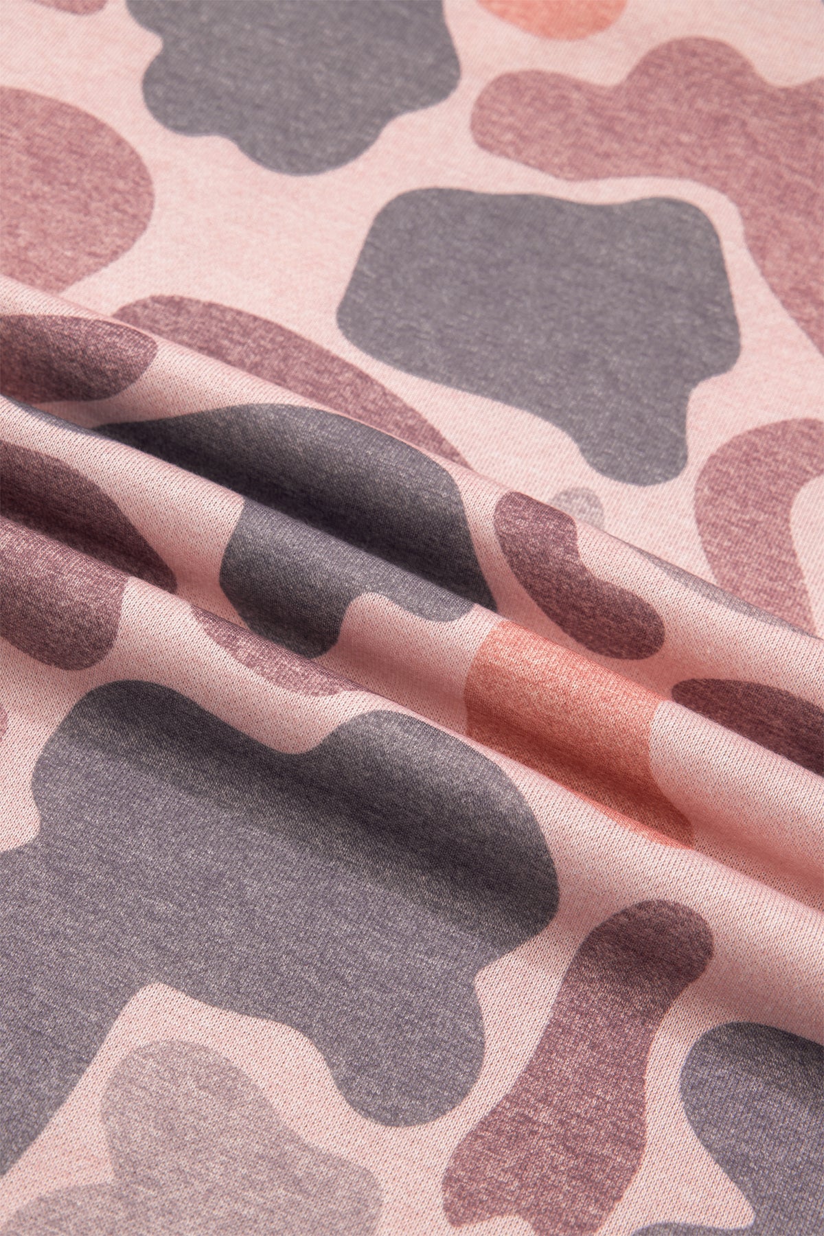 Pink fabric with an abstract camo pattern in shades of purple, gray, and muted red is displayed with gentle folds and a soft texture—ideal for creating the Camo Mock Neck Pullover Sweatshirt.