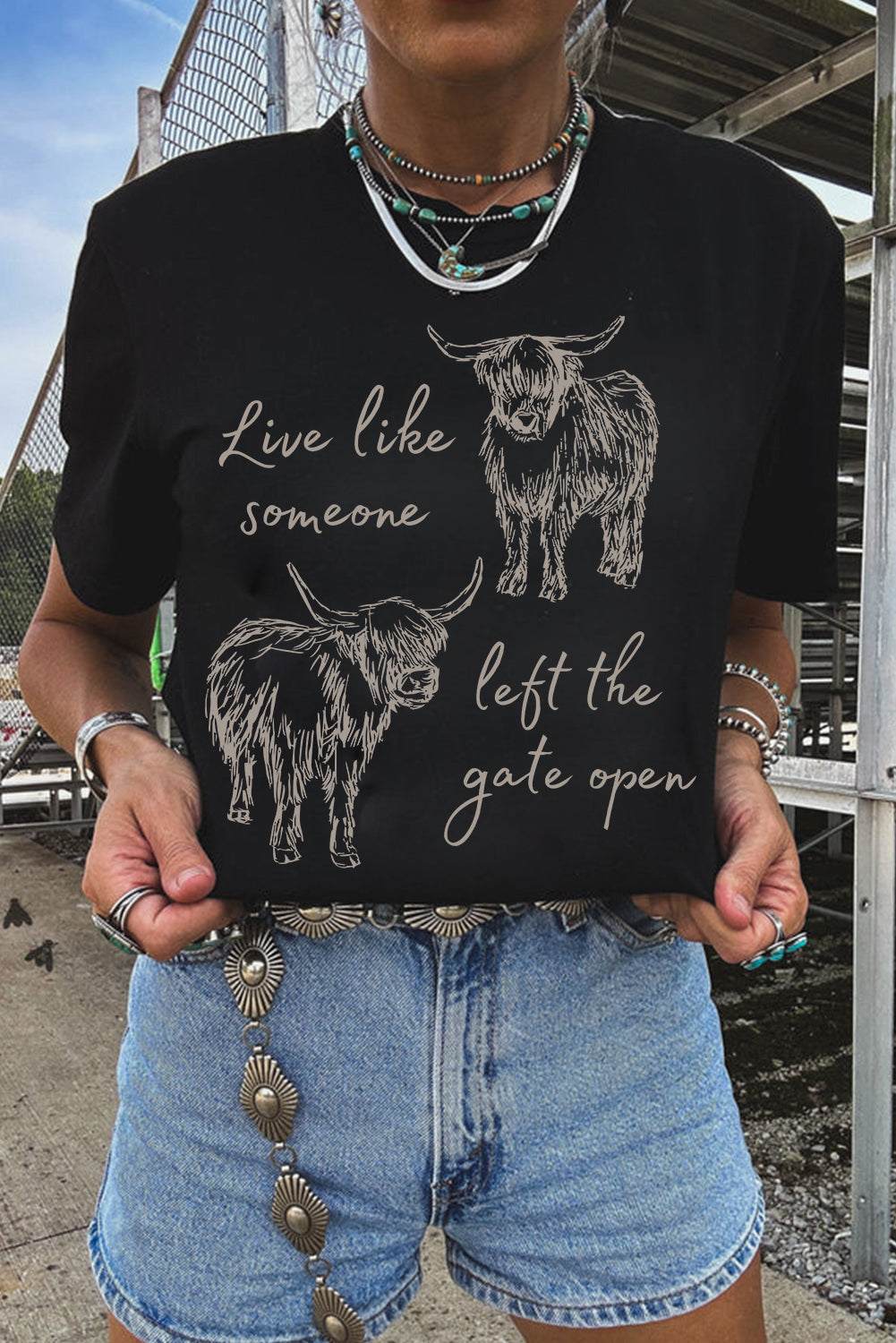 Black Western Cow Print Graphic Tee featuring beige western cow illustrations and script text on a crew neck cotton material.
