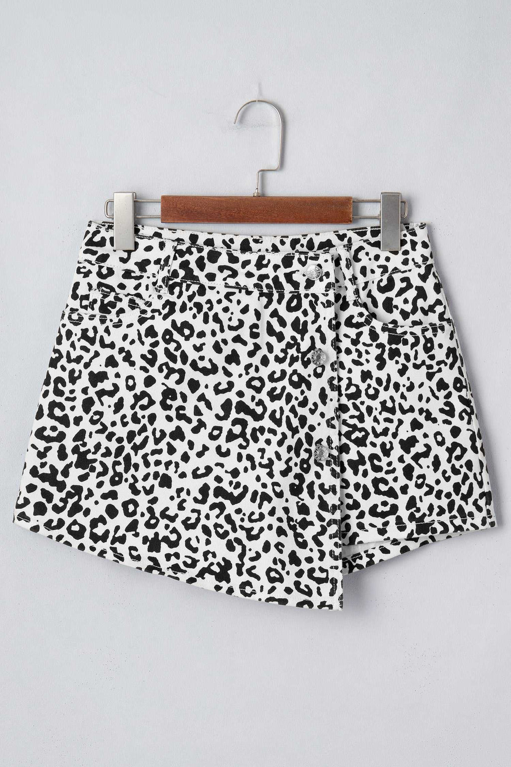 Black Leopard Button Overlap Denim Shorts featuring black and white leopard spots with a unique asymmetrical button overlap design.