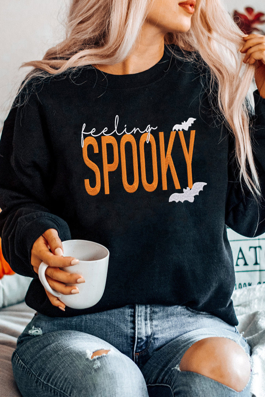 Women's black baggy sweatshirt with embroidered Feeling Spooky lettering