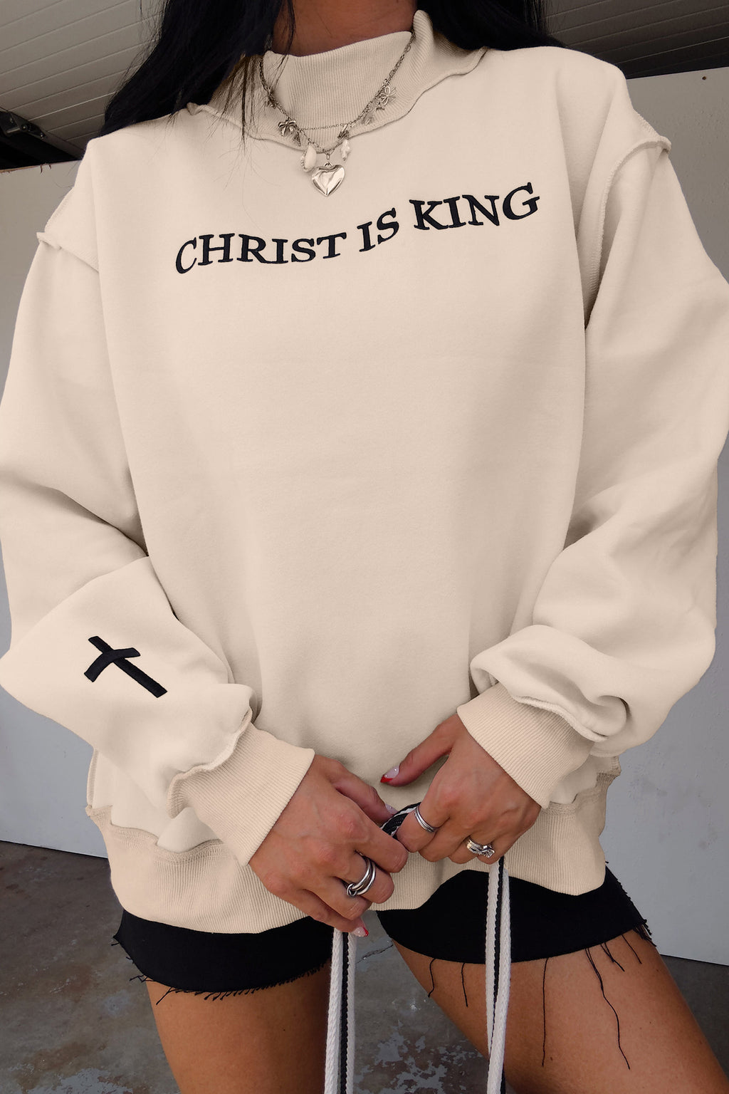 Original model detail view of the Beige CHRIST IS KING Embroidery High Neck Baggy Sweatshirt