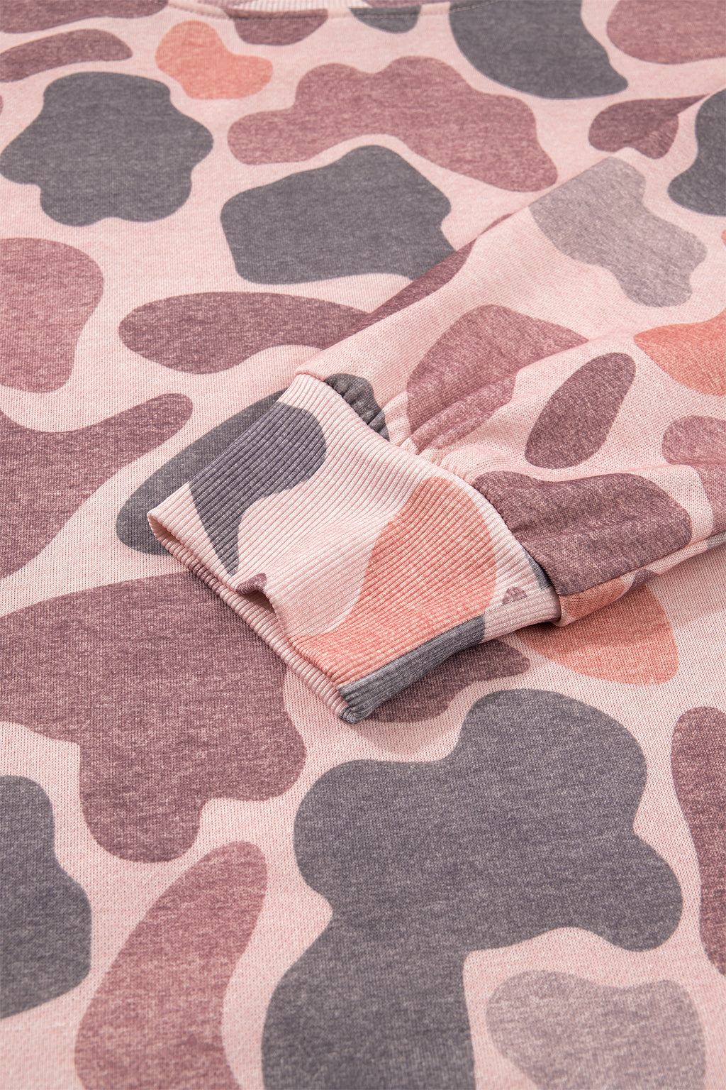 Close-up of a sleeve on the Camo Mock Neck Pullover Sweatshirt in pink, grey, and beige camouflage pattern, highlighting the ribbed cuff and soft fabric texture.