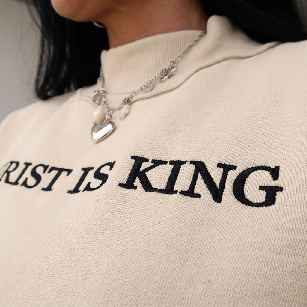 Detail close-up shot of the high-quality embroidery stitching and cozy mock neck fabric of the sweatshirt